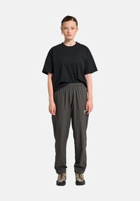 Zwarte katoen T-shirt met een ronde hals en korte mouwen, gecombineerd met donkergrijze, losse trainingsbroeken met een elastische tailleband.
