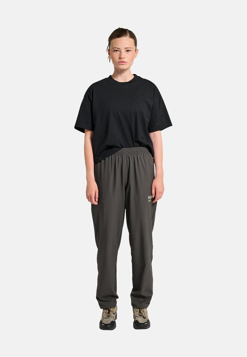 Zwarte katoen T-shirt met een ronde hals en korte mouwen, gecombineerd met donkergrijze, losse trainingsbroeken met een elastische tailleband.