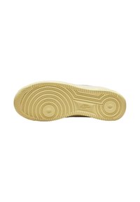 Sola in gomma beige di sneaker Nike, caratterizzata da modelli di battistrada circolari e ondulati, bordi testurizzati e un logo visibile vicino all'area del tallone.