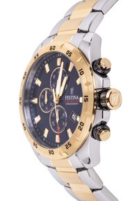 Kronografo laikrodis su juodu ciferblatu, auksiniu ir sidabriniu nerūdijančio plieno korpusu, trimis subciferblatais, datos langeliu ir tekstūruota karūnėle.