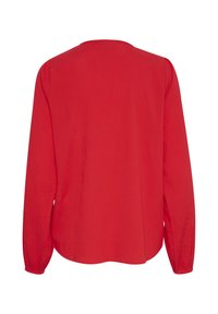 Röd långärmad blus med rund hals, lättviktigt tyg, slät textur och kurvad nederkant. Inga synliga knäppningar eller mönster.