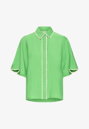 Svetlozelená blúzka s krátkymi rukávmi, špicatým golierom a bielym vlnkovým lemovaním pozdĺž zapínania na gombíky, goliera a okrajov rukávov.