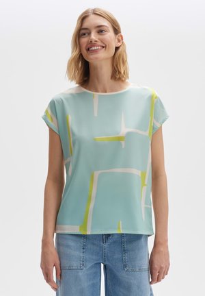 lichtblauwe blouse met korte mouwen, voorzien van abstracte geometrische patronen in wit en felgeel. Soepele stof met een losse pasvorm.