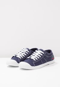 Sneakers in tela blu con lacci bianchi, punta in gomma e ricamo colorato di ciliegie di lato. Presentano dettagli di cucitura a contrasto.