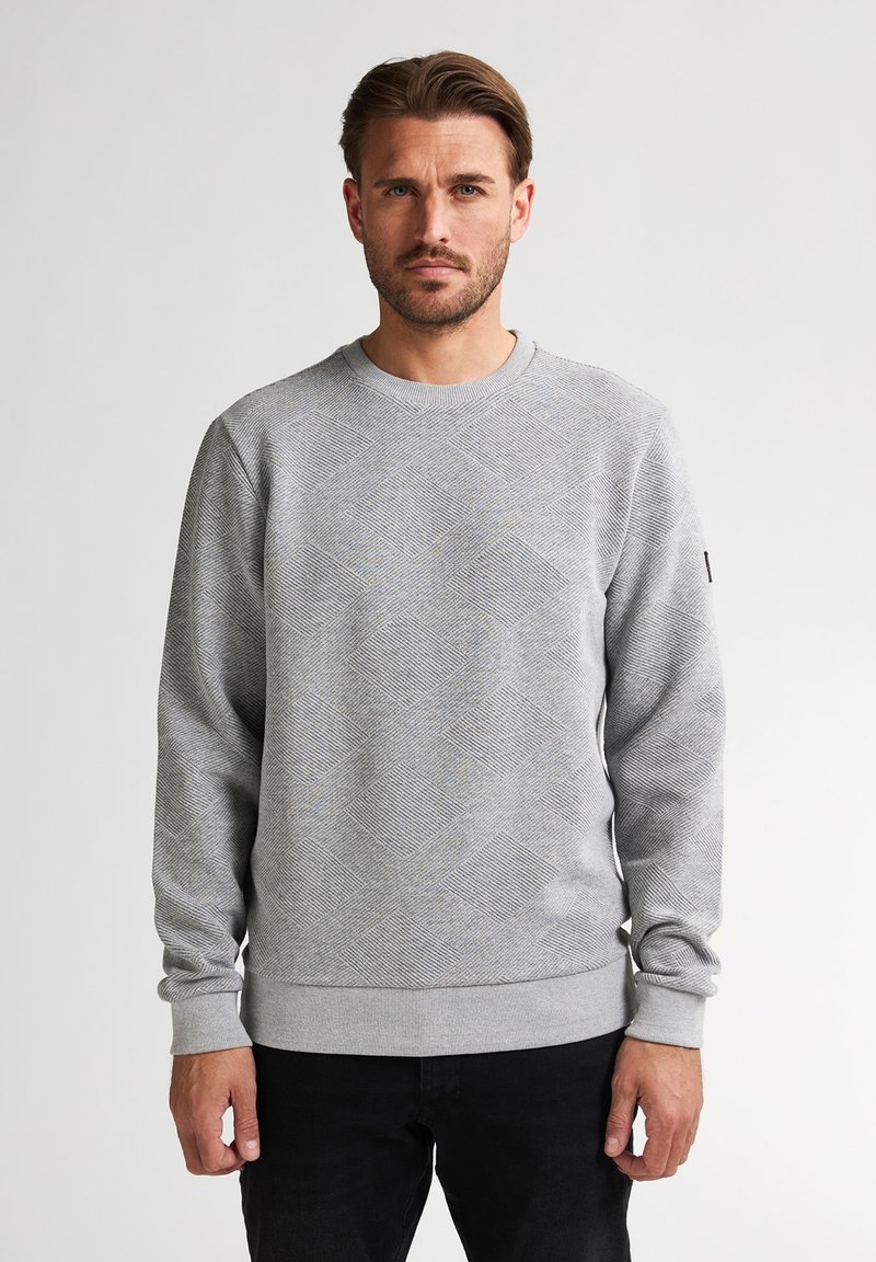 Grijze sweatshirt met een getextureerd ruitpatroon, geribde manchetten en een ronde halslijn. Gecombineerd met zwarte broeken voor een casual look.