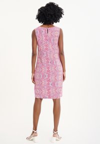 Robe sans manches au design ajusté, présentant un motif géométrique rose et blanc, longueur genou, avec un détail en forme de clé à l'arrière.