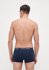 Navy boxer briefs made of soft fabric, featuring a white elastic waistband with "JACK & JONES" logo, fitted style, and short leg design.