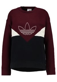 Mikina s kulatým výstřihem, burgundská horní část, černá dolní část, bílý chevronový pruh a velké bílé logo Adidas trefoil na hrudi.
