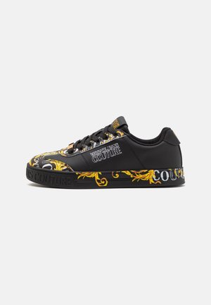 Schwarzer und goldener Versace Jeans Couture Sneaker mit floralen Barockmustern und gebrandetem Text an der Seite und Sohle, Schnürdesign.