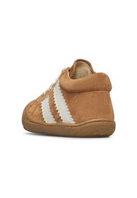 Scarpa per toddler in suede marrone con strisce zigzag bianche, lacci bianchi e suola in gomma, vista dal retro lato destro.