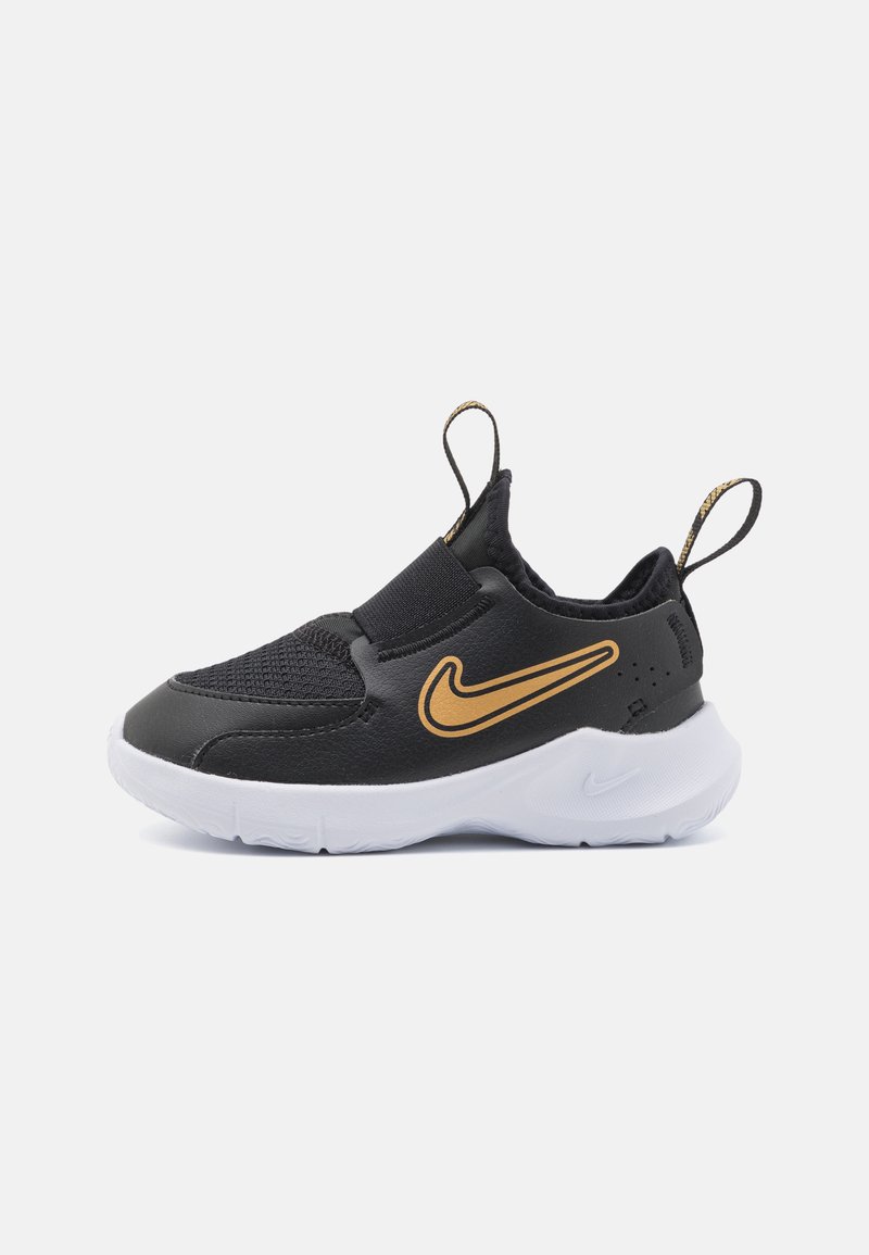 Black athletic shoes with a mesh upper, orange Nike swoosh, elastic strap across the midfoot, and white rubber outsole.