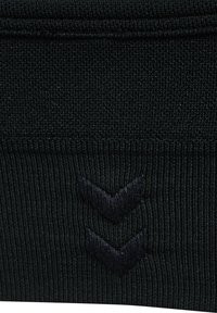 Schwarzer Strickstoff mit einer gerippten Struktur zeigt ein dunkles Emblem mit zwei nach unten gerichteten Chevron-Zeichen, das zentriert nahe dem unteren Rand angebracht ist.