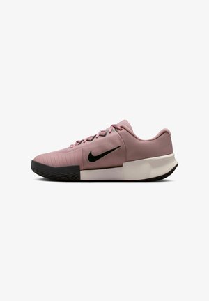 Chaussure de sport basse mauve avec semelle noire, logo Nike noir, dessus en mesh et lacets roses, vue de profil sur fond blanc.