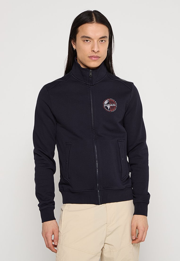 Mörkblå zip-up sweatshirt i tjock bomull, med hög krage, två framfickor och en broderad logotyp på vänstra bröstet.