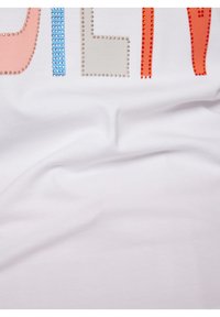 White t-shirt featuring multicolored lettering embellished with rhinestones in pink, blue, gray, and orange, with a smooth, soft texture.