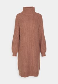 Robe-pull à col roulé tricotée de couleur rouille, avec un tissu texturé, des manches larges et des fentes latérales pour faciliter les mouvements.