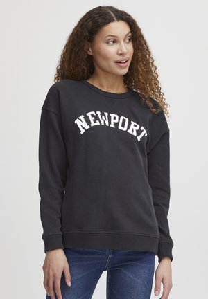 Svart hettegenser med rund hals, med hvit «NEWPORT» tekst i en buet design. Laget av mykt stoff med ribbestrikkede mansjetter og kant.