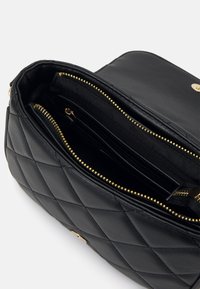 Borsa a tracolla in pelle nera trapuntata con dettagli in oro, dotata di un vano principale e numerose tasche interne per l'organizzazione.