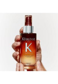 Siero Kérastase Nutritive in una bottiglia trasparente con effetto ombre, dotato di un pompetta argentata e scritte bianche. 90 ml.