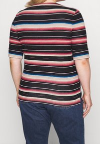 Vícebarevný krátký rukáv top s horizontálními pruhy v černé, červené, modré a béžové barvě. Materiál vypadá hladce a má mírný lesk.