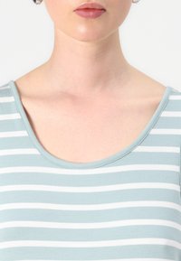 Lichtblauw en wit gestreept shirt met een ronde halslijn en een zachte textuur. De strepen zijn gelijkmatig en de stof lijkt soepel.