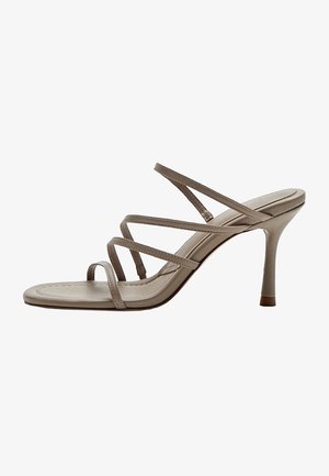 Beige højhælet sandal med tynde krydsede remme og åben tå på en slank stiletthæl.