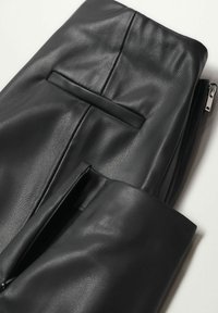 Pantalons en cuir noirs avec une texture lisse, un design ajusté et un détail de poche arrière avec fermeture éclair.