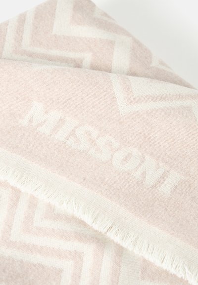 Tissu tissé rose doux et blanc avec motif en zigzag, bordure à franges et le mot « MISSONI » subtilement intégré dans le tissu.