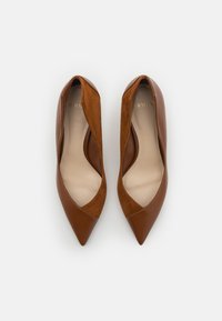 Bailarinas puntiagudas de cuero marrón y ante con un diseño de bajo corte, que presentan un panel en contraste de color marrón claro y un interior suave en beige.