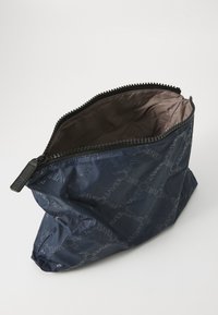 Tamnoplavi zippered etui napravljeno od izdržljive tkanine, sa mat teksturom i suptilnim uzorkom ponovljenog teksta na vanjskoj strani. Smeđa unutrašnjost.