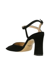 Černé semišové sandály na vysokém podpatku s špičatou špičkou, kotníkovým páskem a robustním podpatkem. Vnitřní stélka je béžová s jemným brandingem.