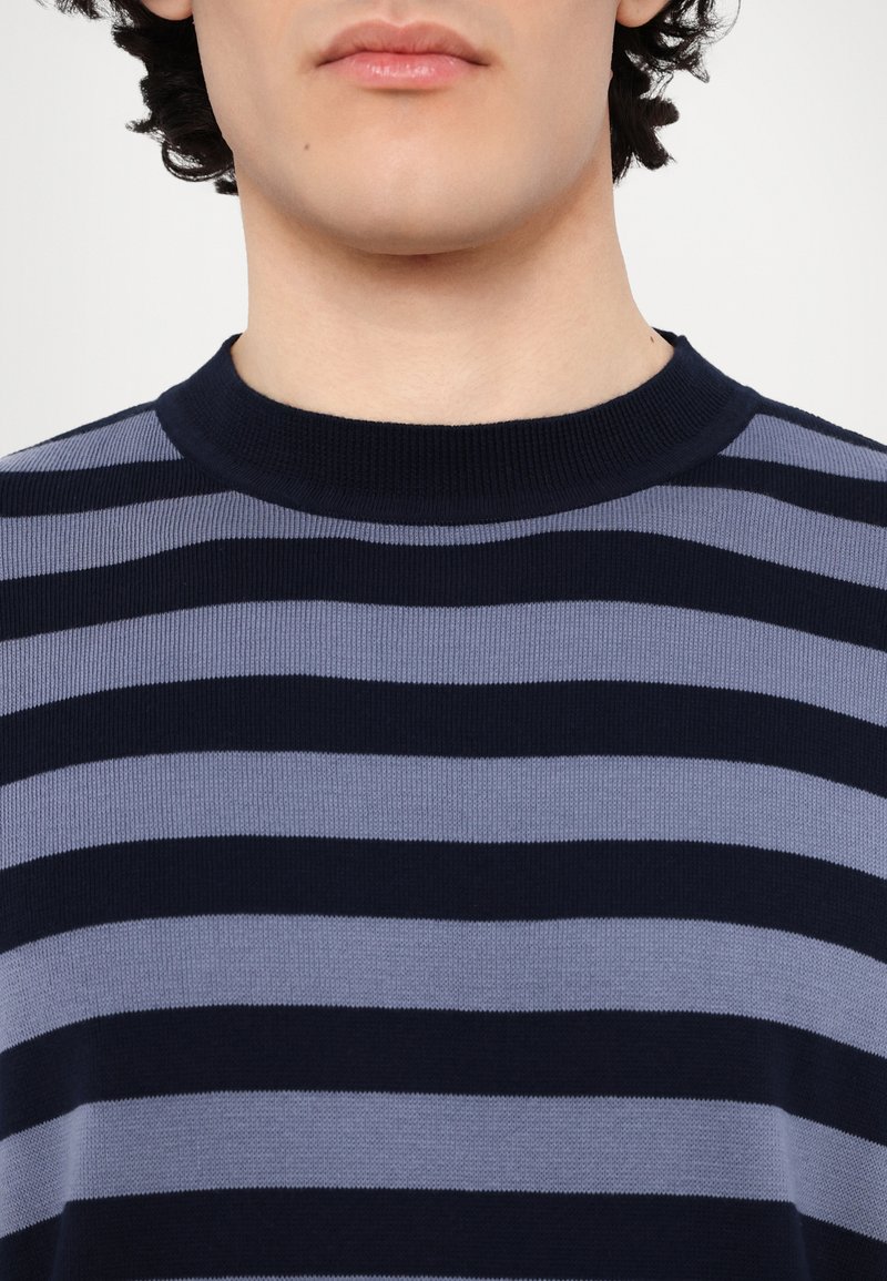 Navy and light gray striped knit sweater with a ribbed crew neckline, featuring a soft texture and even stripe pattern.