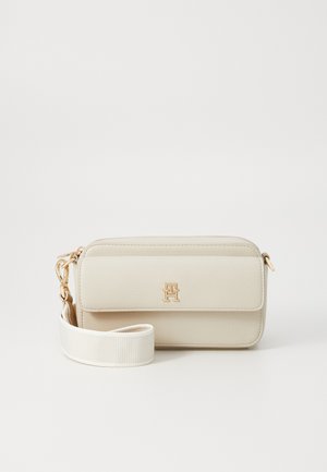 Beige műbőrből készült crossbody táska cipzárral, arany színű fém részletekkel és leválasztható fehér pánttal. Az elején logó található.