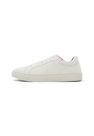 Białe sneakersy o gładkiej fakturze, okrągłym nosku i subtelnym kontrastującym akcentem w kolorze tan na pięcie. Płaska gumowa podeszwa i wiązana konstrukcja.