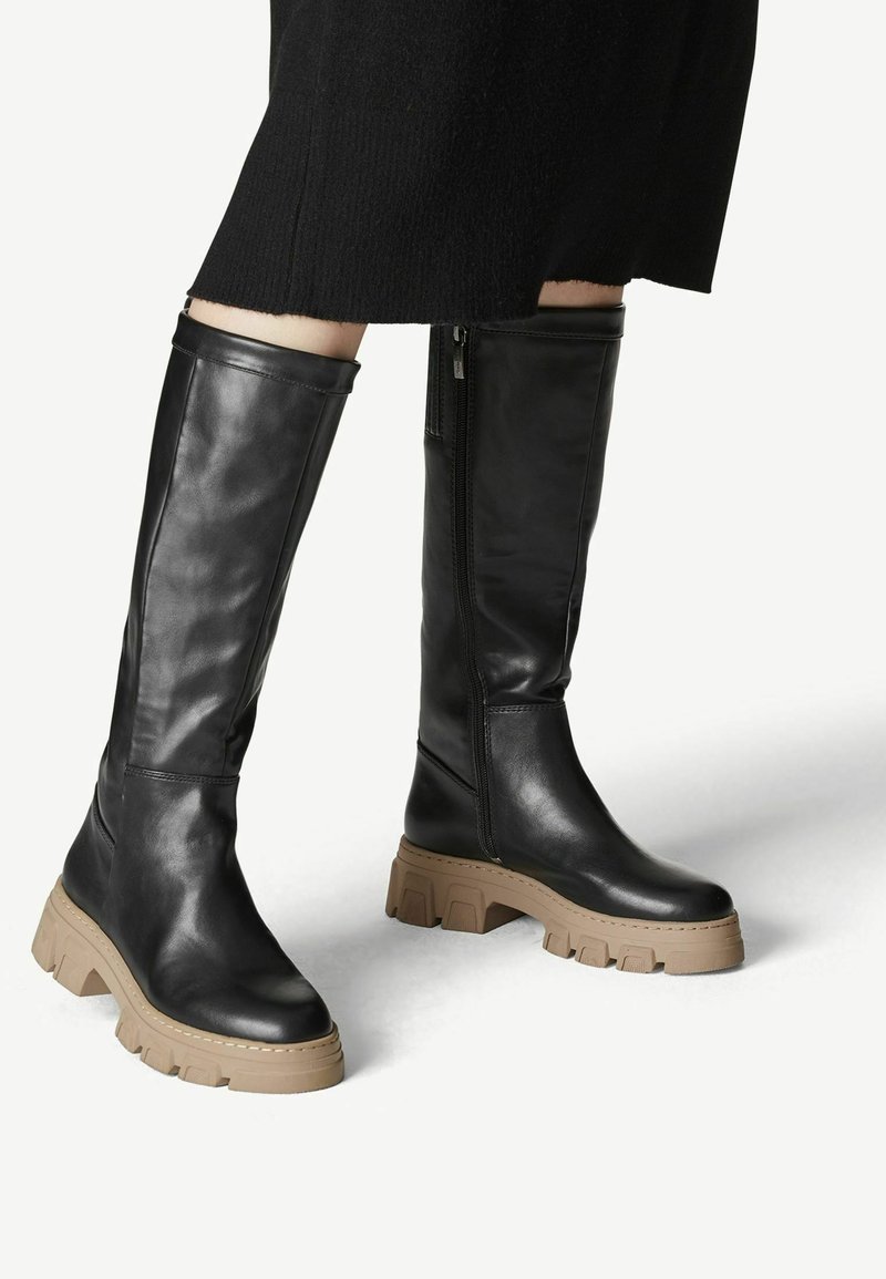 Stivali neri in pelle al ginocchio con suola spessa beige, dotati di zip laterale e texture liscia.