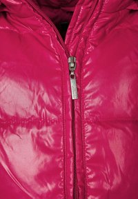 Růžová vatovaná bunda z hladké, lesklé látky. Má přední zip s kovovým jezdcem a prošité části pro izolaci.