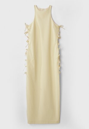 Yellow sleeveless dress with a high neckline, featuring side ties for adjustable fit and a smooth, soft texture. Simple and straight silhouette.