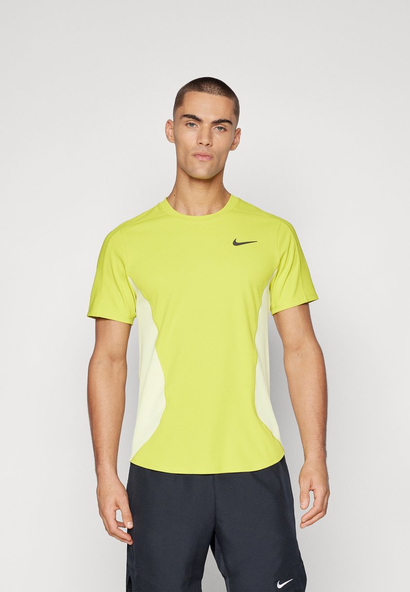 Limegrøn atletisk skjorte med korte ærmer, sort Nike-logo på brystet, kontrasterende hvide sidepaneler og rund halsudskæring.