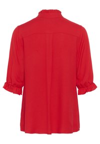 Blusa rossa con colletto arricciato e maniche 3/4 elastiche. Tessuto morbido con una leggera lucentezza e design svasato.