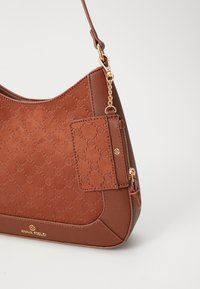 Bolso marrón de Anna Field con patrón de logo en relieve acolchado, cremallera dorada y detalles de cadena, además de un tarjetero a juego desmontable.