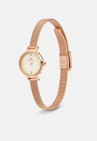 Runde Damenarmbanduhr mit cremefarbenem Zifferblatt, roségoldenem Edelstahl-Mesh-Armband, minimalistischem Design und kleinen Stundenmarkierungen.