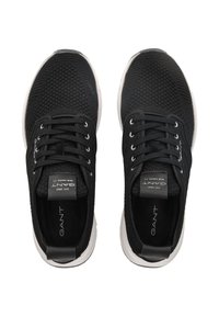Paire de baskets en tissu tricoté noir avec semelles blanches, design à lacets et marque "GANT" sur la languette et la semelle intérieure, vue de dessus.