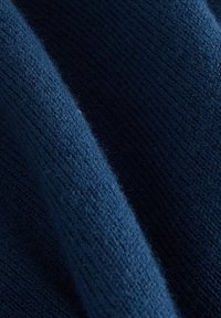 Námornícky modrý pletený materiál s jemným, textúrovaným povrchom; má rebrovaný vzor, ktorý poskytuje hĺbku a vizuálny záujem.