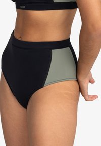 Hochgeschnittene Bikiniunterteile in Schwarz und Olivgrün, aus dehnbarem Material mit flachen Nähten und einer glatten Textur.