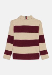 Pulover tricotat bej cu dungi orizontale bordeaux, guler înalt și manșete cu dungi. Prezintă un detaliu contrastant cu dungi la guler.