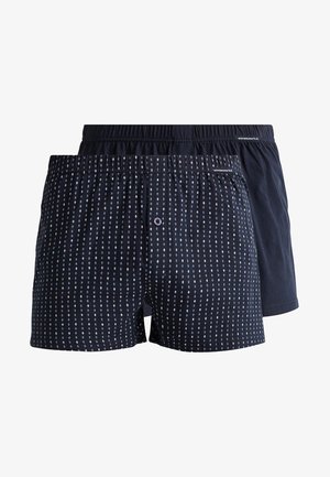 Boxershorts aus dunkelblauem Baumwollstoff. Ein Paar ist mit einem gepunkteten Muster versehen, während das andere einfarbig ist. Beide haben einen elastischen Bund.