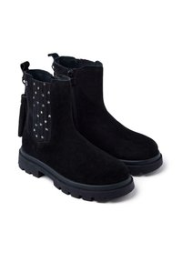 Botas de tobillo de ante negro con un panel frontal texturizado que presenta acentos de estrellas doradas, cremalleras laterales y suelas de goma negra gruesa.