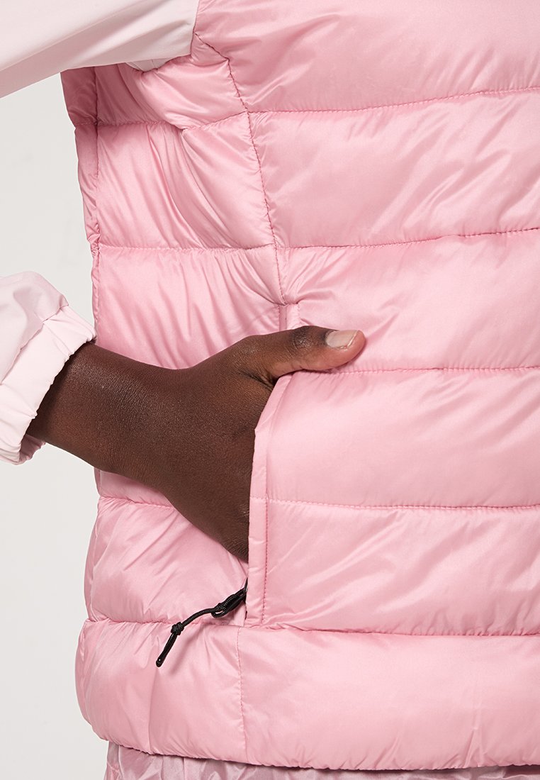 Rosa, gepolsterte Weste mit gestepptem Textur und Kontrastnähten. Verfügt über eine Reißverschlusstasche an der Seite und einen elastischen Saum für eine bequeme Passform.