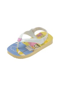 Tongs blanches en caoutchouc avec une bride texturée, présentant un design coloré de personnages de dessin animé et un semelle intérieure jaune, bleue et à motifs.