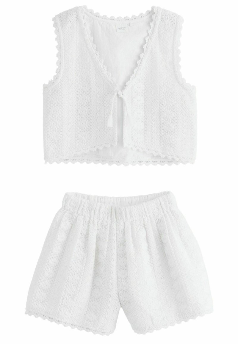 White two-piece set featuring a cropped sleeveless top with a tie closure and elastic waistband shorts, both in textured fabric with scalloped edges.